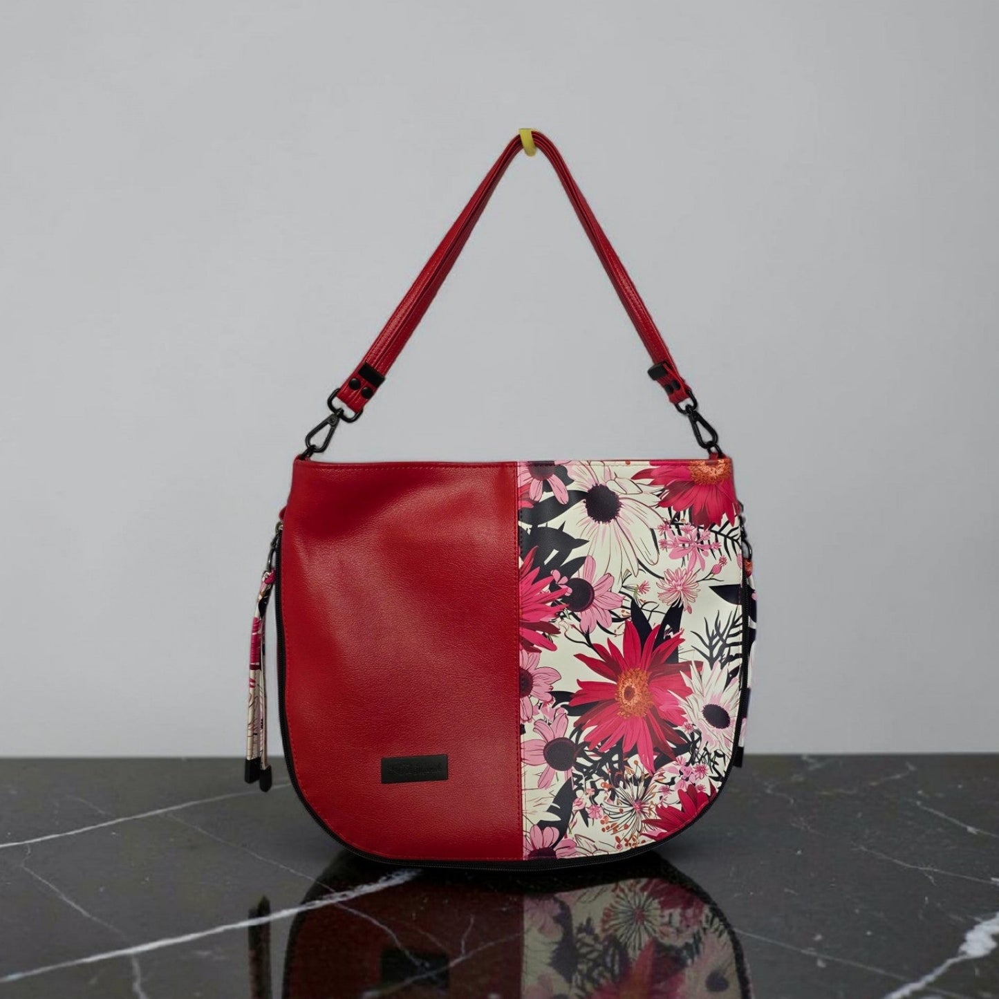 Red floral print slouch bag, matte black hardware.