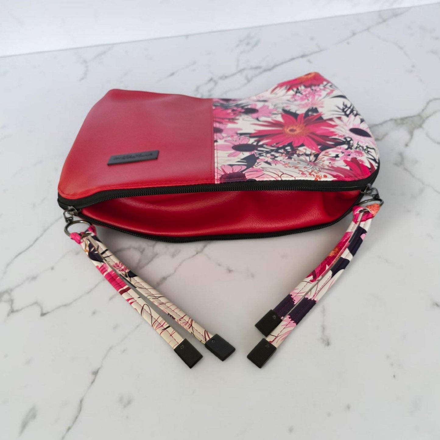 Red floral print slouch bag, matte black hardware.